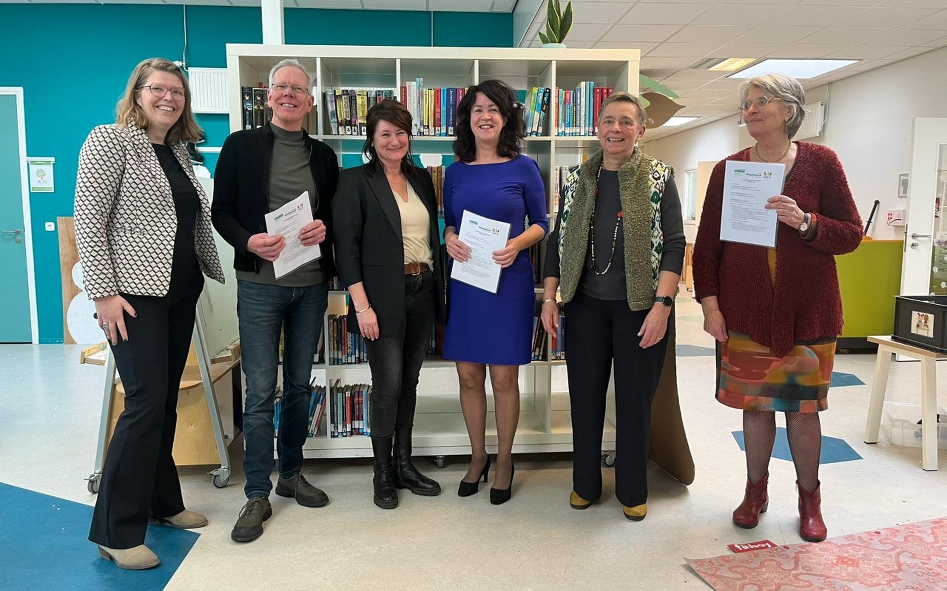 Vertegenwoordigers van de drie organisaties met de ondertekende contracten. Eigen foto