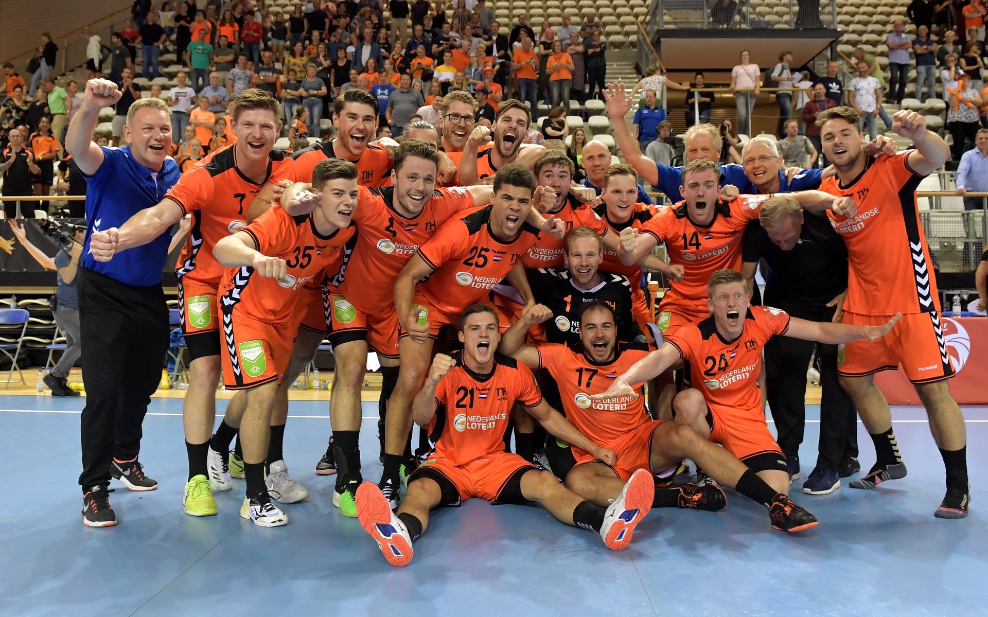 De Nederlandse handbalmannen vieren plaatsing voor het EK. Helemaal achteraan Erlingur Richardsson.
