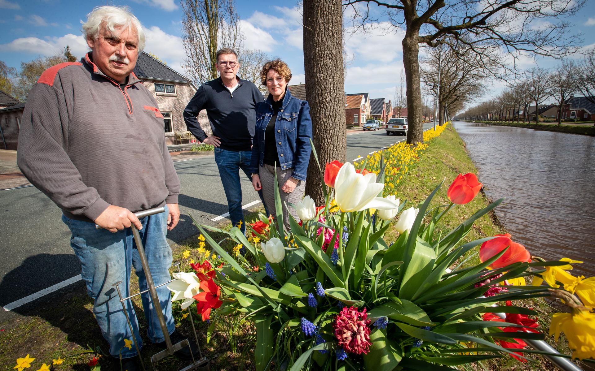 Evert Kaspers (l) met zijn contraptie en Wim en Greetje Lageman bij de bloemenpracht langs het Stadskanaal.