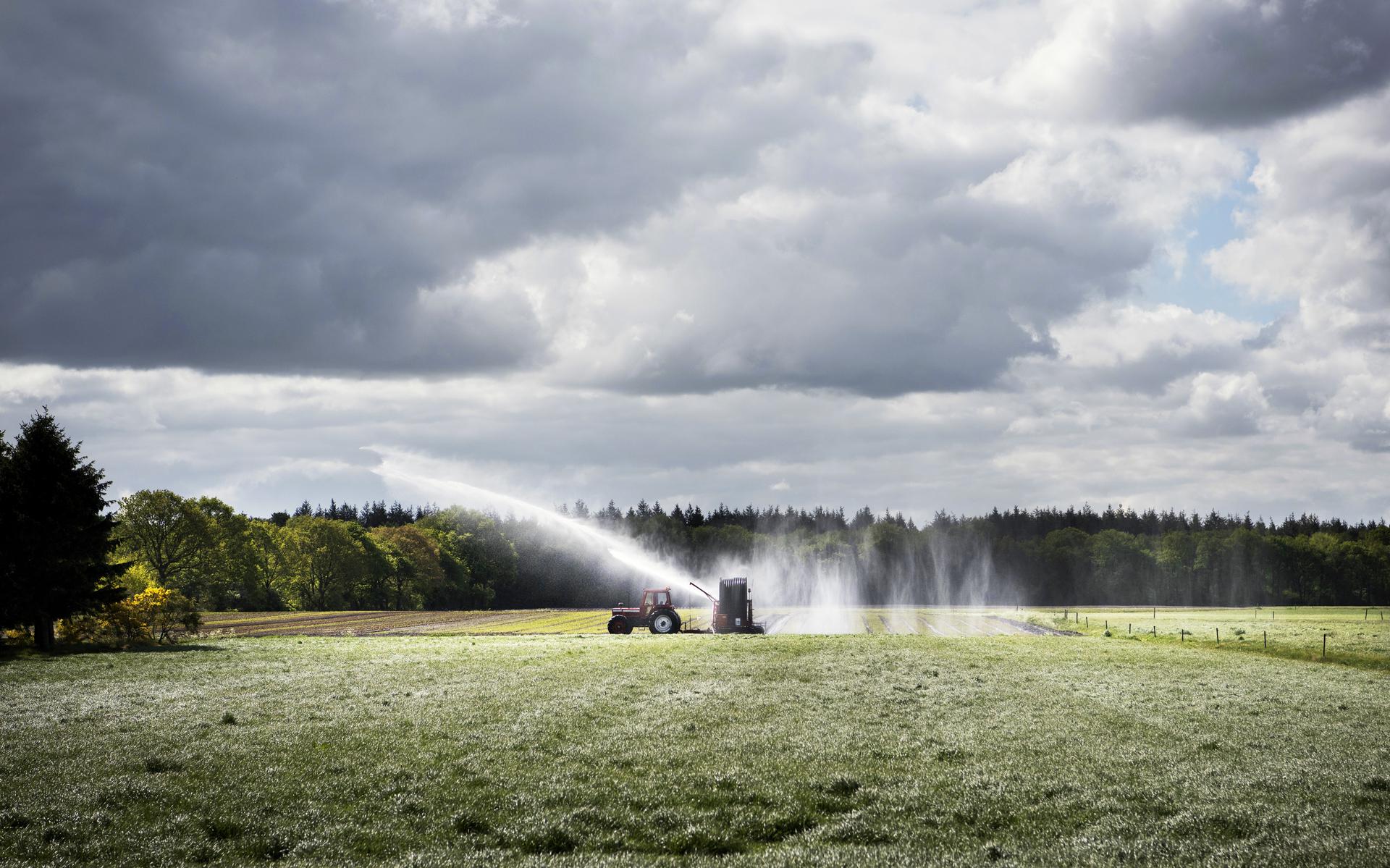 Een Drentse boer bestrijdt de droogte op zijn land in de buurt van Schoonloo.