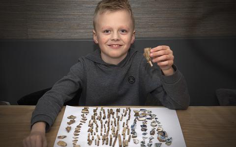 Coevordenaar Jesse Smeeman (8) toont zijn omvangrijke collectie stokoude pijpenkoppen en scherven die hij zondag heeft opgegraven.