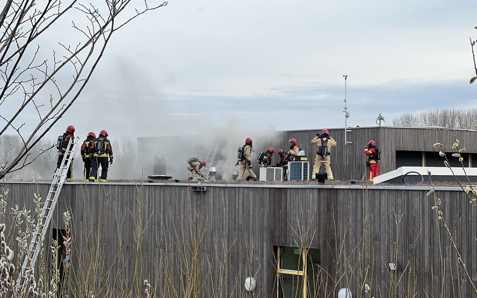 Brandweermannen op het dak van het crematorium.