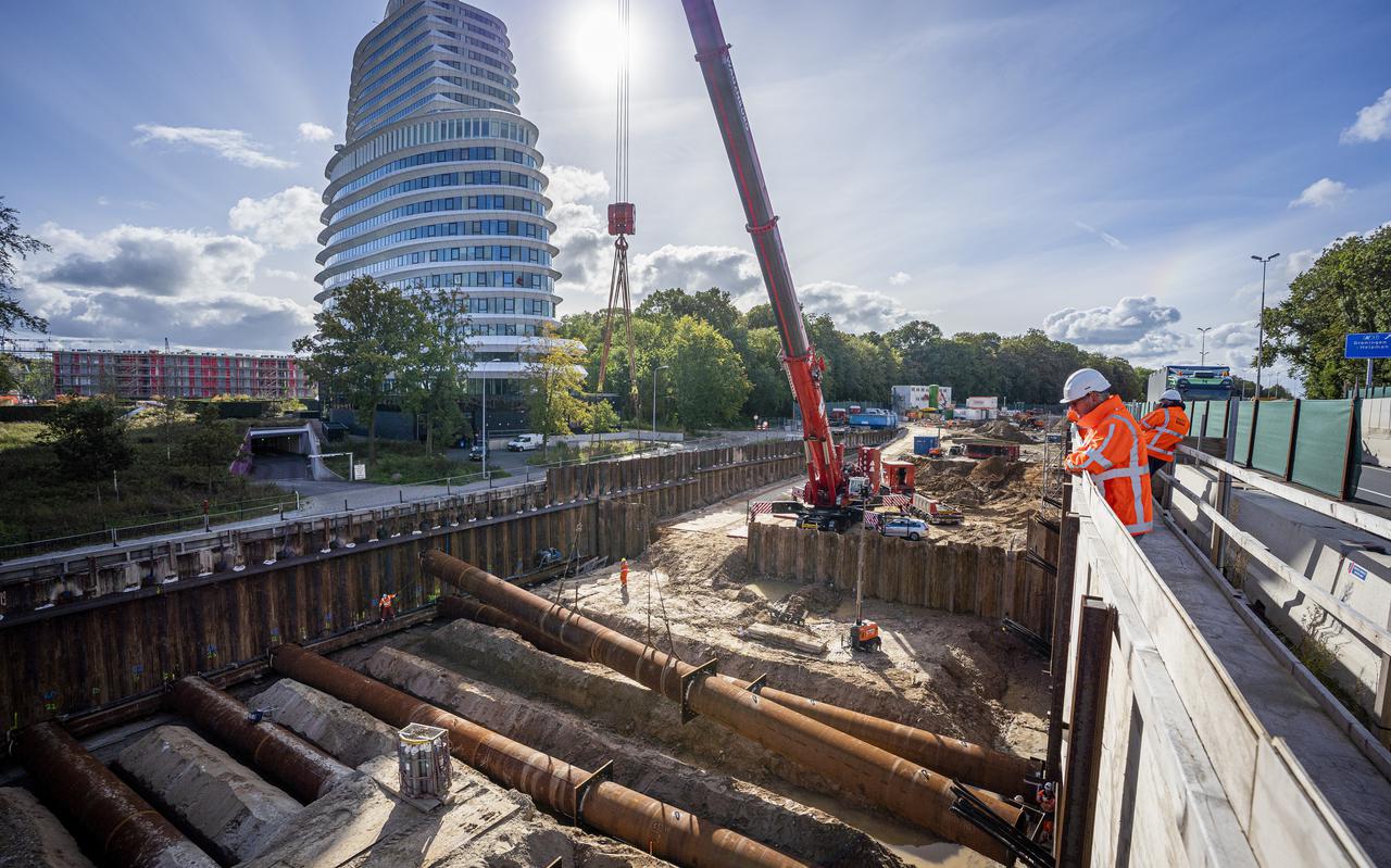Bouwers van Combinatie Herepoort kijken naar hun collega's die aan de slag zijn met het uitgraven van de bouwput voor de verdiepte ligging van de nieuwe ringweg in Groningen. Er komen drie tunnels in. 