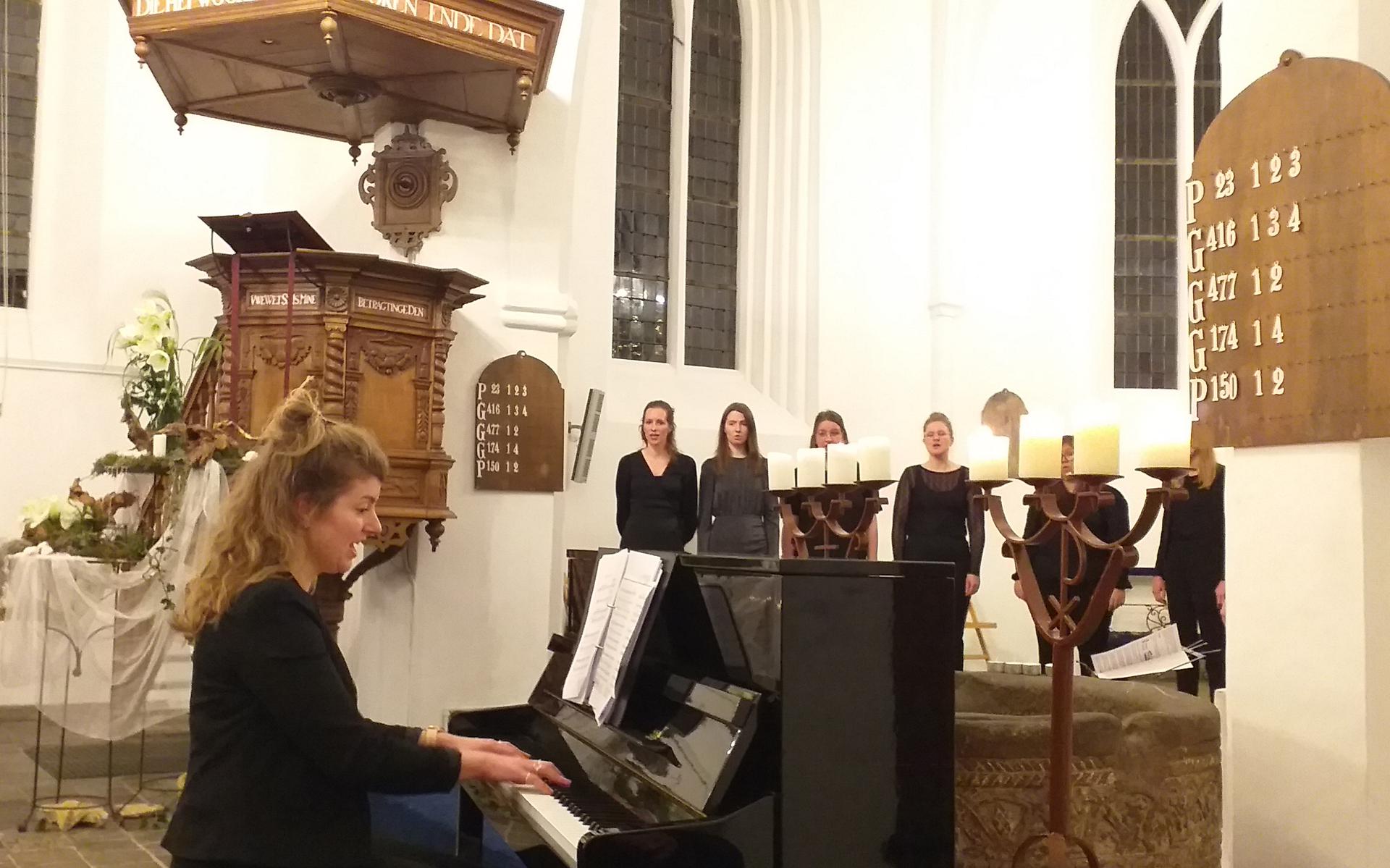 Dirigent en pianist Mirna Westra van vrouwenkoor Nova (achtergrond) hier stijlvol in actie.