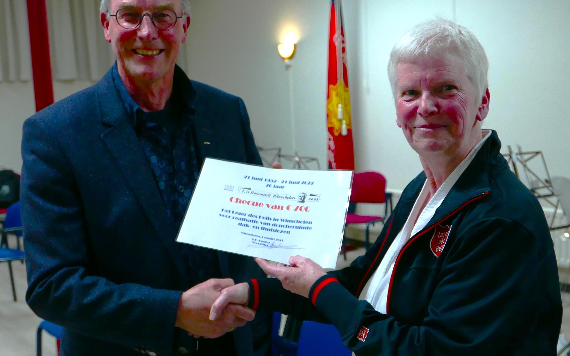 Voorzitter Simon Gerdez van de Roosevelt Loge overhandigt de cheque aan kapitein Bineke Berkenbosch van het Leger des Heils.