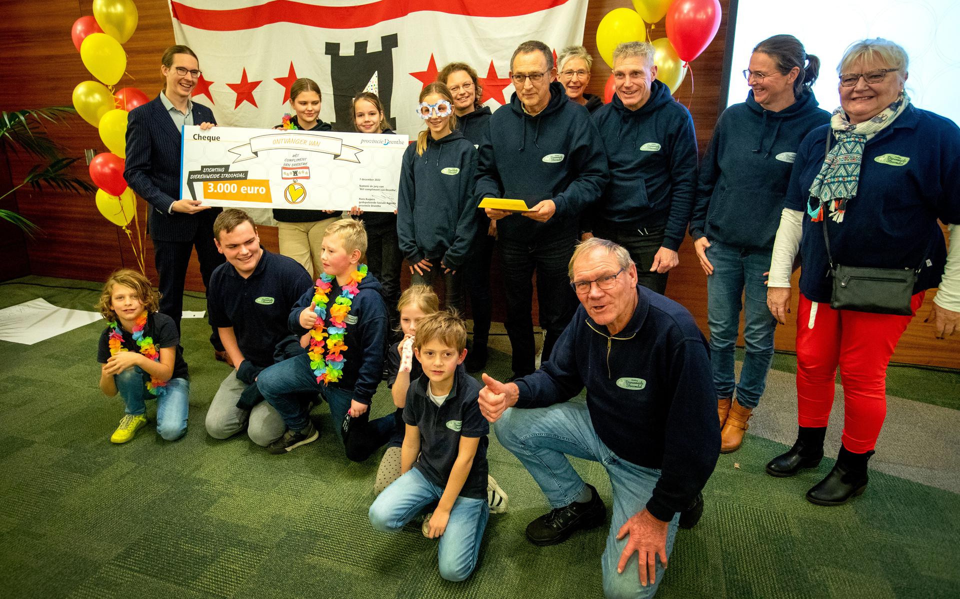 De vrijwilligers van Stichting Dierenweide Stroomdal nemen het Compliment van Drenthe in ontvangst van gedeputeerde Hans Kuipers.