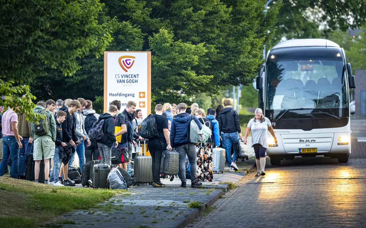 Groep leerlingen stapt voor het schoolgebouw van CS Vincent van Gogh Lariks op de bus naar Berlijn.