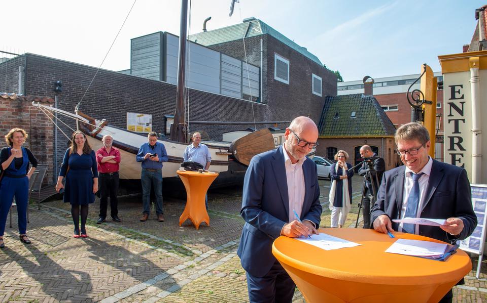 Groninger Museum-directeur Andreas Blühm (links) en zijn collega Jan Wiebe van Veen van het Noordelijk Scheepvaartmuseum en het toekomstige Museum aan de A ondertekenen als eerste van de vier partners de definitieve samenwerkingsovereenkomst. 