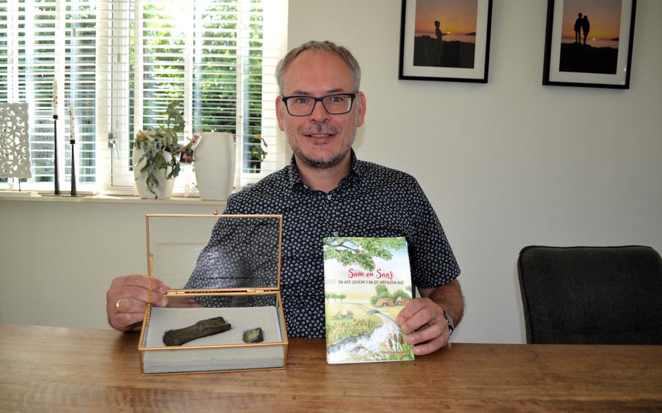 Otto Torenbosch met de gevonden bronzen bijl en het proefmodel van zijn kinderboek. 