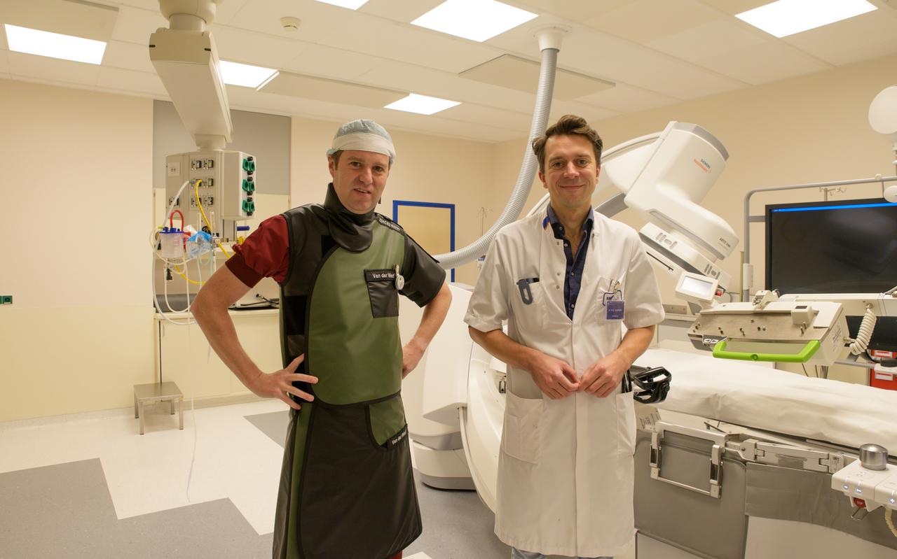 Cardiologen Rik van der Werf (links) met een zwaar loodvest aan en Michael Dickinson van het UMCG die hulp krijgen van een dotterende robot. Cardiologen Rik van der Werf (links) met een zwaar loodvest aan en Michael Dickinson van het UMCG die hulp krijgen van een dotterende robot.