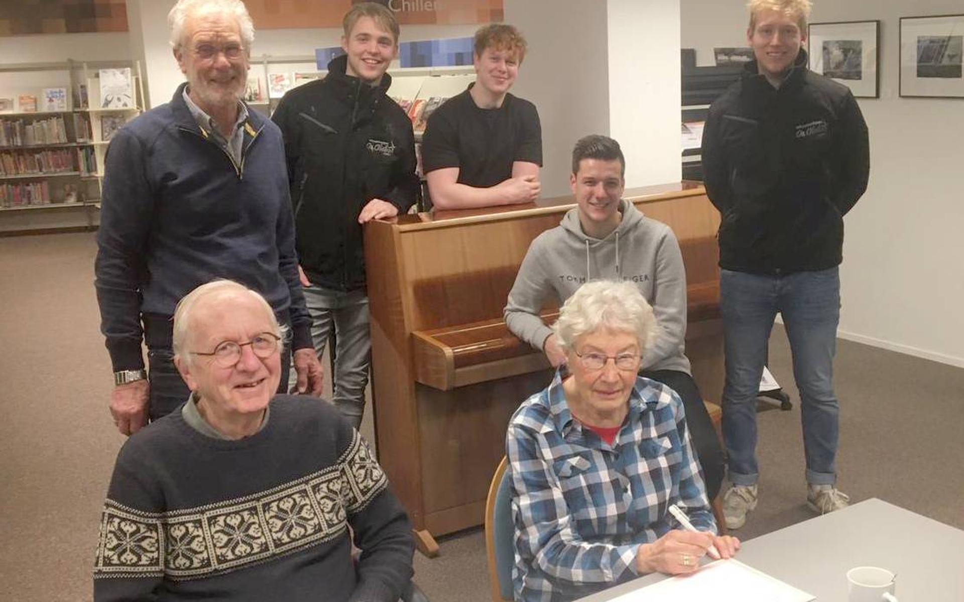 Ondertekening van de akte van overdracht door Annie de Jonge en Dirk Boom (voorzitter Naobuur). Daarachter Geert Pijlman (bestuurslid Naobuur) en rond de piano vier mannen van OJP De Oliebol die voor de verhuizing van de piano hebben gezorgd.
