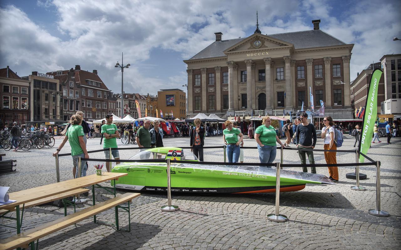 Voorbijgangers laten zich op de Grote Markt bijpraten over de Green Lighting voor hun en het nieuwere model, de Green Spirit. Laatstgenoemde vertrekt binnenkort voor een Solar Challenge naar Marokko.
