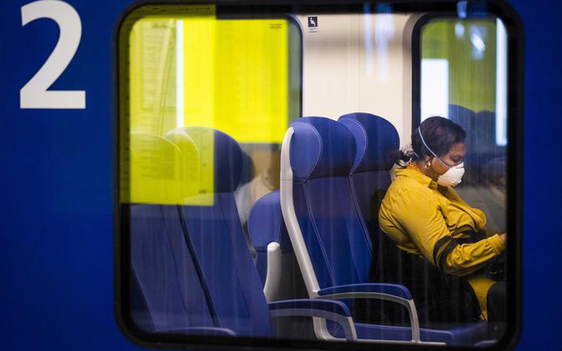 Een treinreiziger met een mondkapje op.