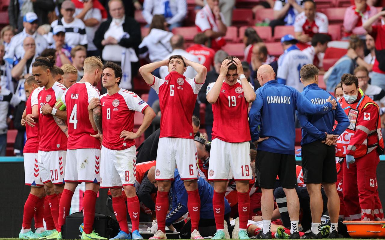De spelers van Denemarken vormen een beschermende ring om hun ploeggenoot Christian Eriksen. De spelers van Denemarken vormen een beschermende ring om hun ploeggenoot Christian Eriksen.