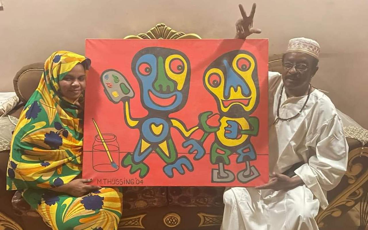 Het schilderij van Michiel Thijssing tijdens de overhandiging in Soedan. Links de zus van Aladin uit Groningen, rechts kunstenaar Rashid Diab.