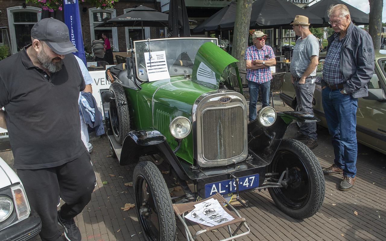 De groene Opel-oldtimer, bijna 100 jaar oud, van Rudy Hanenberg (rechtsachter met rode bril). Rechtsvoor bezoeker Jan-Hendrik Oving. 
