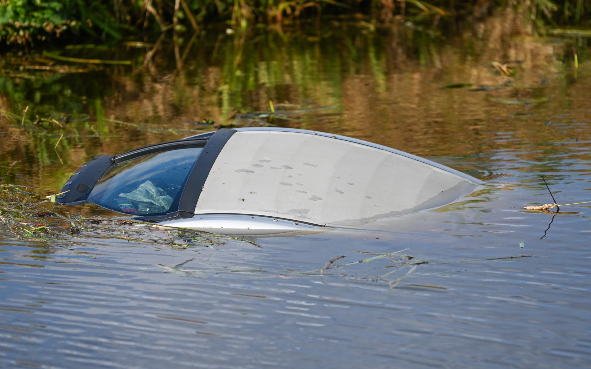 Auto belandt in het water bij de Vosholen in Sappemeer. Omstanders helpen bestuurder uit het kanaal 