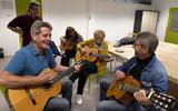 De gitaargroep van TalentenCentrum Coevorden, met links gitaarleraar Klaas Boonstra.