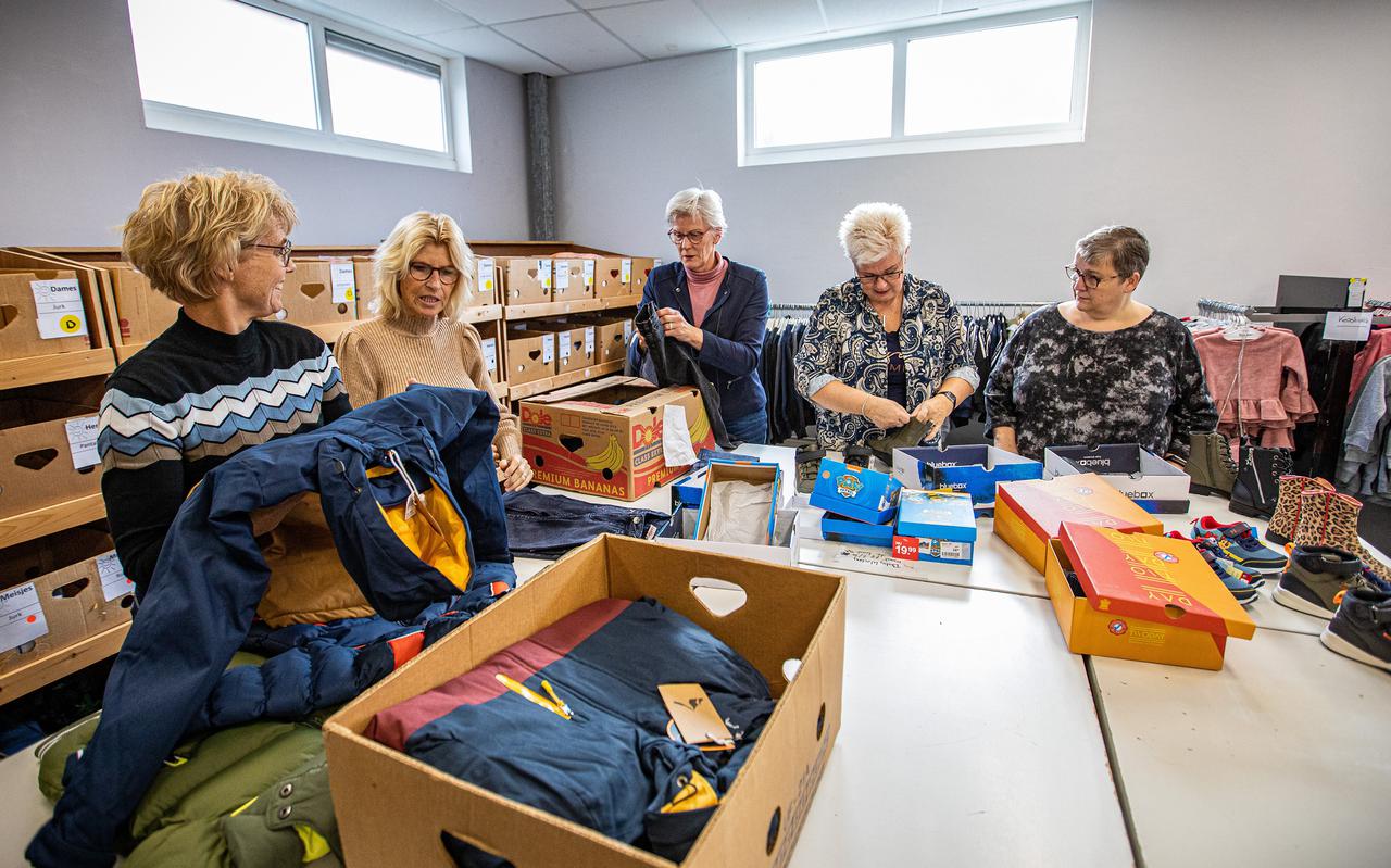 Ina Kuperus (tweede van links) van kledingbank Maxima in Winschoten pakt samen met andere medewerkers de dozen met kleding uit. 