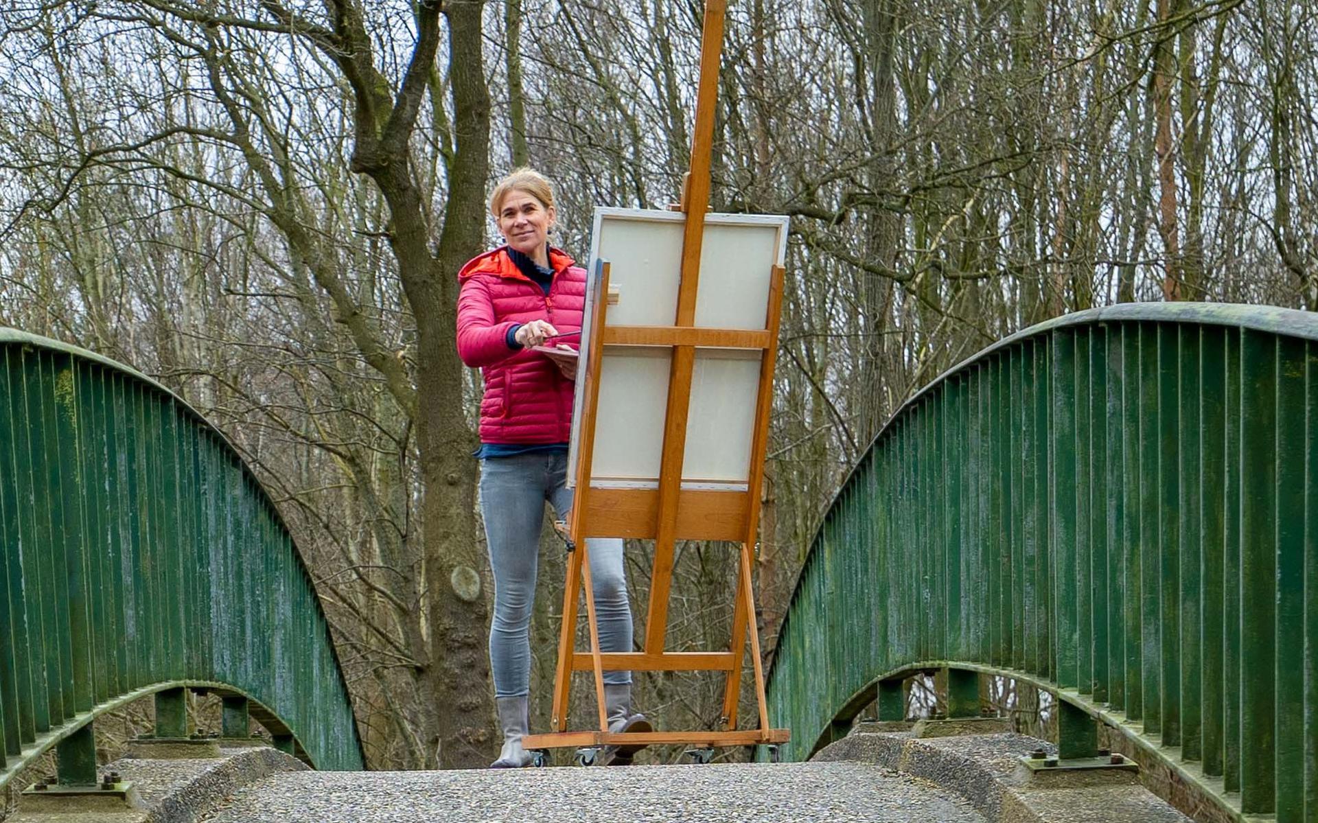 Nicole van der Veen op de boogbrug over het Oranjekanaal, zij zoekt bruggenbouwers voor het maken van een portret.