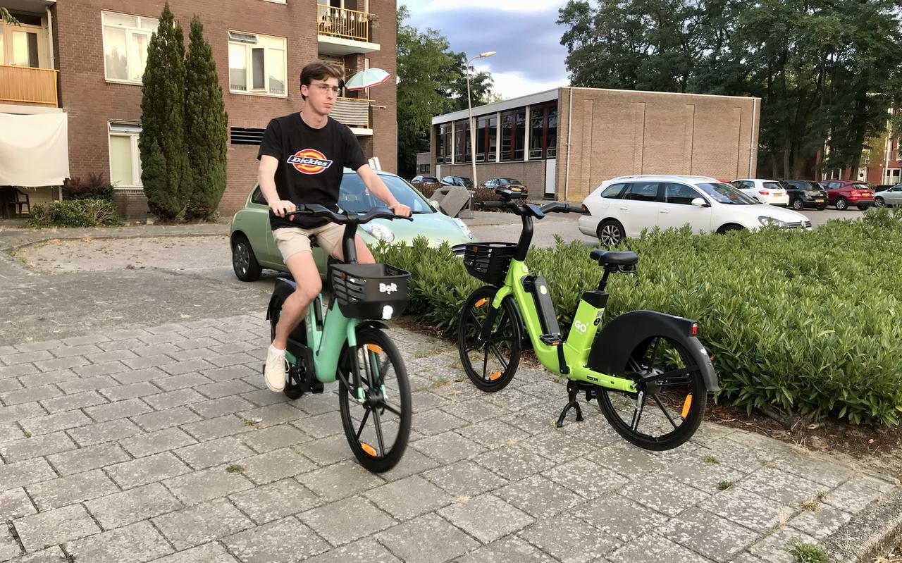 Een fietser op een elektrische deelfiets van Bolt passeert een geparkeerd exemplaar van concurrent Go. Vanaf september staan ze beide in Groningen. Foto: DvhN