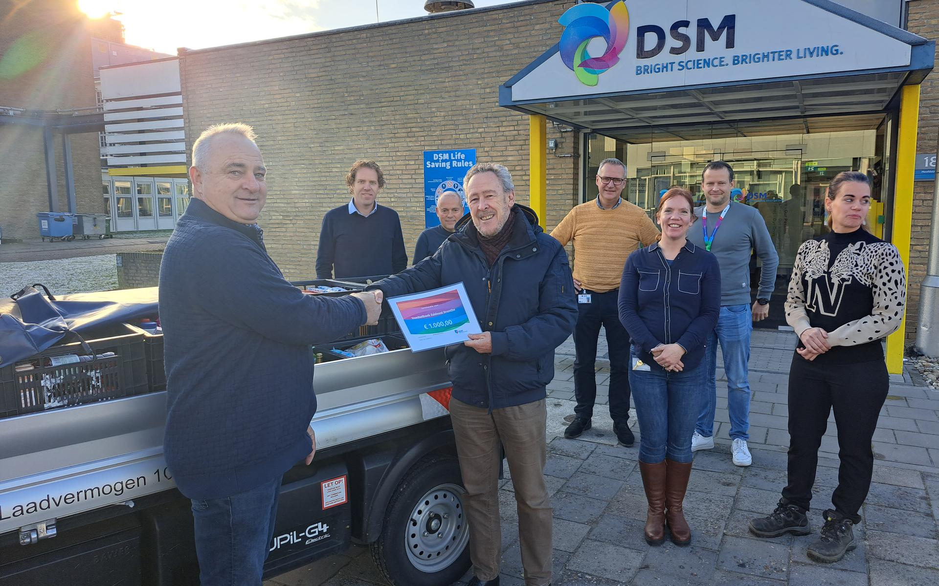 DSM-medewerker Jan Siebum (links) en zijn collega's overhandigen de producten en de cheque aan voedselbankvoorzitter Ton Sleeking.