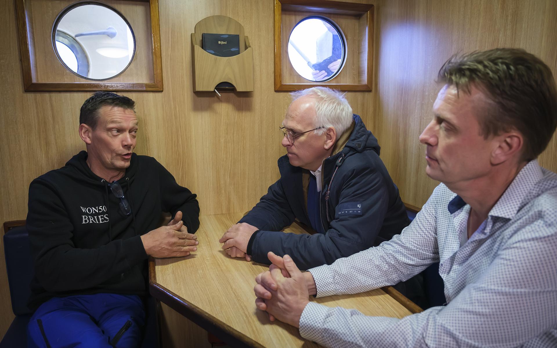Minister Piet Adema (midden) praat in Lauwersoog met garnalenvissers.