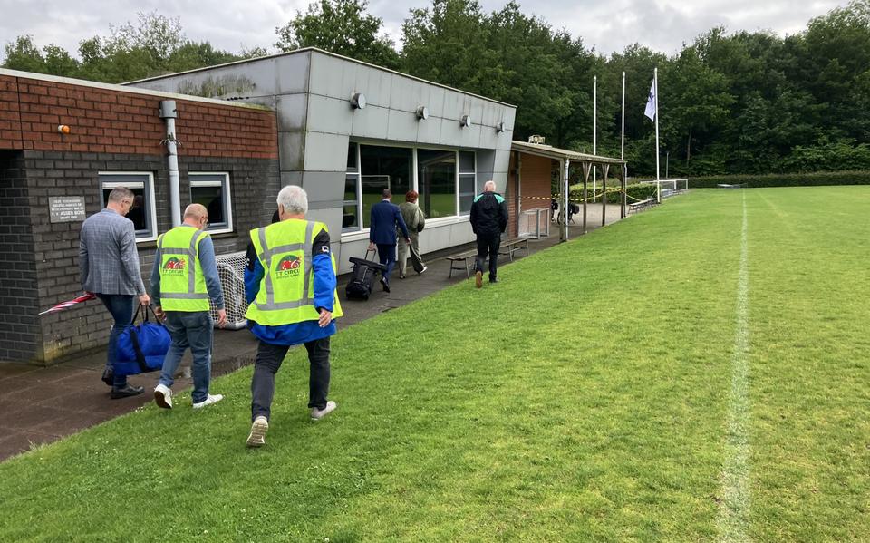 Voorafgegaan door de voorzitters Marion Reinders (Oosterpakkers) en Willem Post (VCG) verlaat scheidsrechter Martin Rozema (met rolkoffer) het complex van Asser Boys.