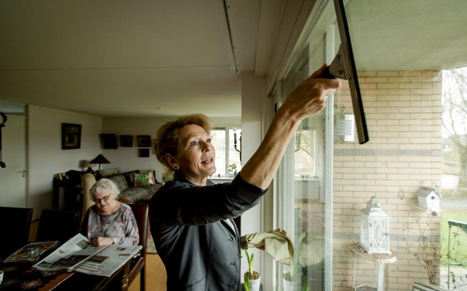 Een medewerkster van thuiszorgorganisatie Buurtzorg helpt de bewoonster met het huishouden. 