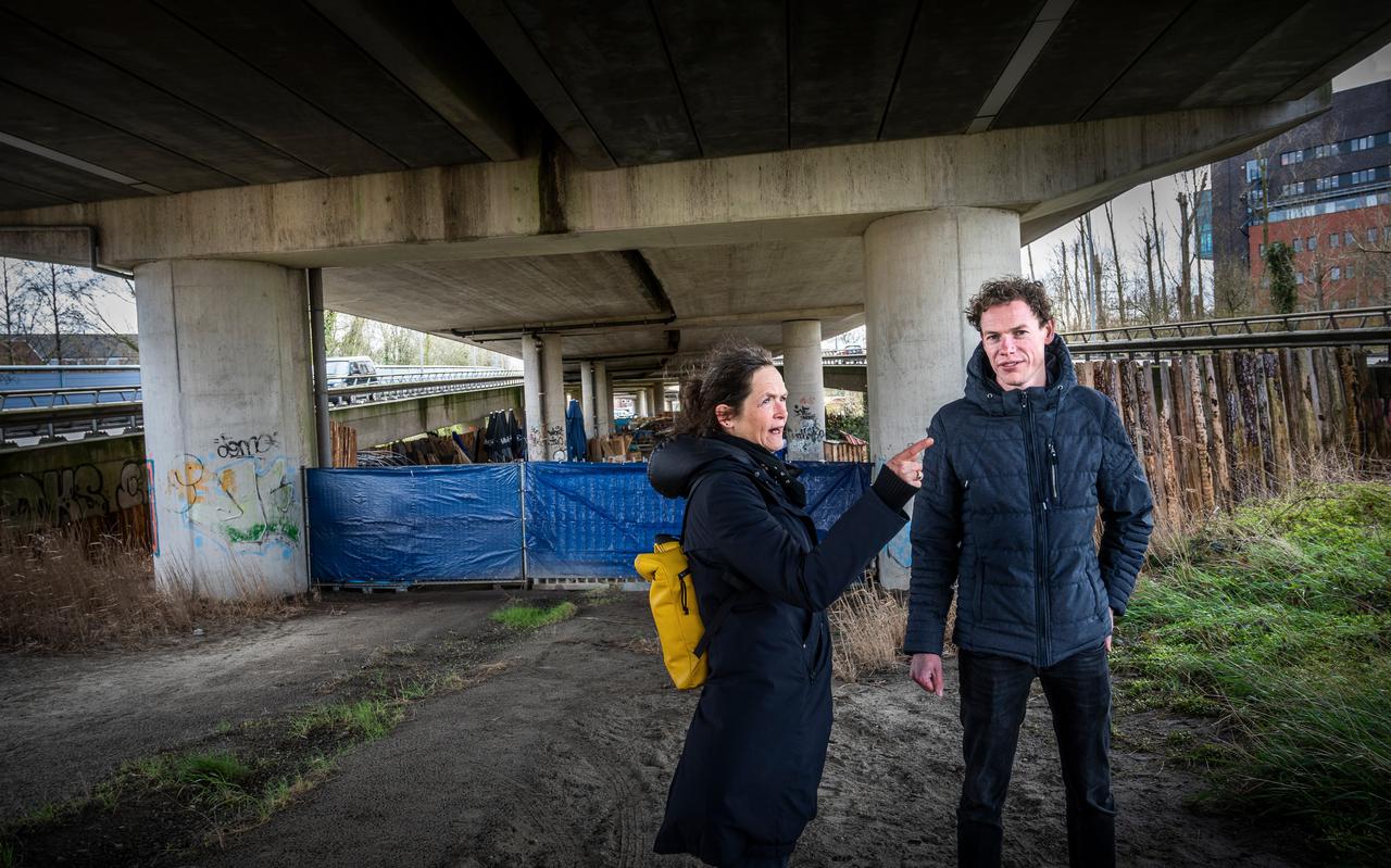 Arie Pater (Lentis) en Thea Bulthuis (VNN) onder het viaduct in Groningen waar eerder een paar van hun cliënten sliepen in illegale caravans of tenten.