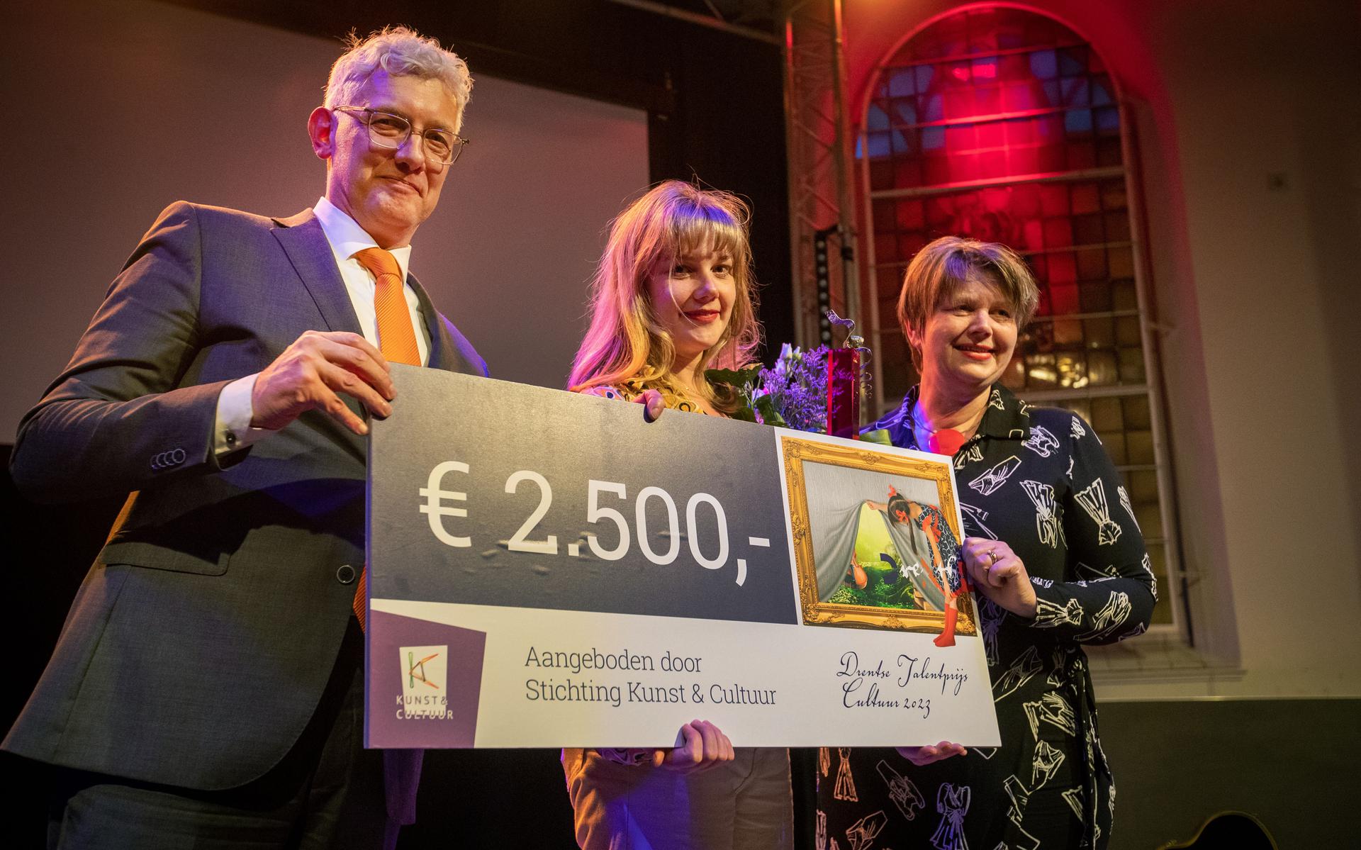 Stella van den Sigtenhorst (midden) neemt namens Firma Frictie - en daarmee dus ook Lusanne Arts - de Drentse Talentprijs in ontvangst, uit handen van Marco Out en Marieke Vegter. 