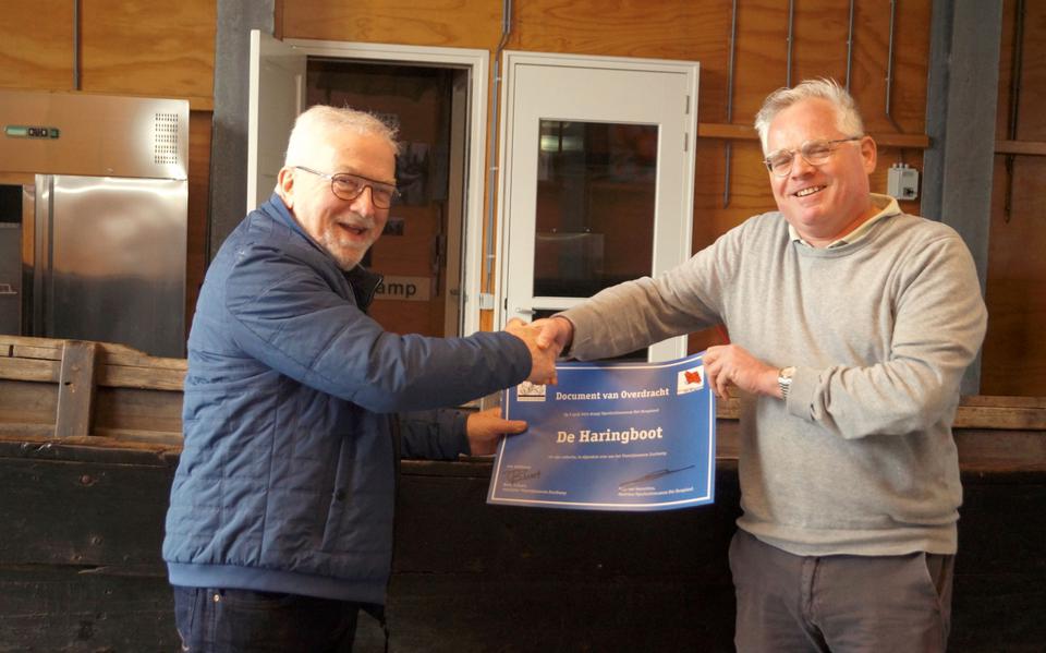 Voorzitter Berend Zwart van het Visserijmuseum (links) krijgt het overdrachtsdocument uit handen van directeur Stijn van Genuchten van Openluchtmuseum Het Hoogeland. Eigen foto