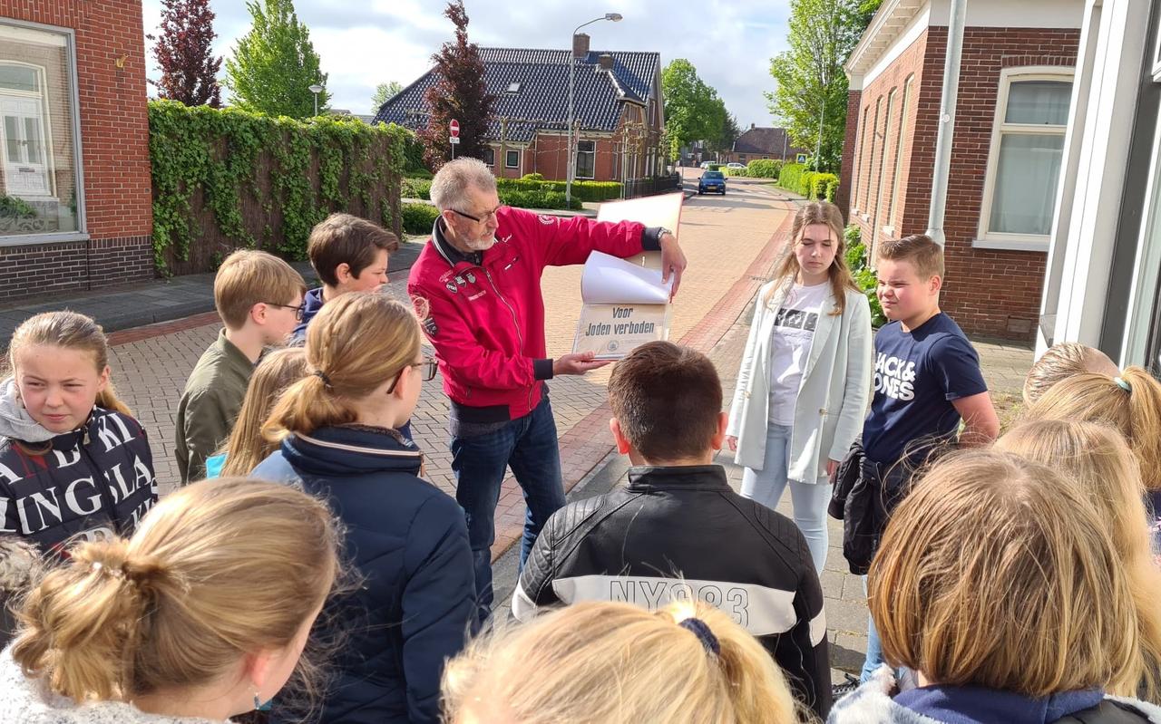 Chris Scholtens (rode trui) in mei met schooljeugd in Noordbroek. Scholtens geeft deze maand soortgelijke rondleidingen in Slochteren en vertelt dan over wat zich daar in de Tweede Wereldoorlog afspeelde. Chris Scholtens (rode trui) in mei met schooljeugd in Noordbroek. Scholtens geeft deze maand soortgelijke rondleidingen in Slochteren en vertelt dan over wat zich daar in de Tweede Wereldoorlog afspeelde.