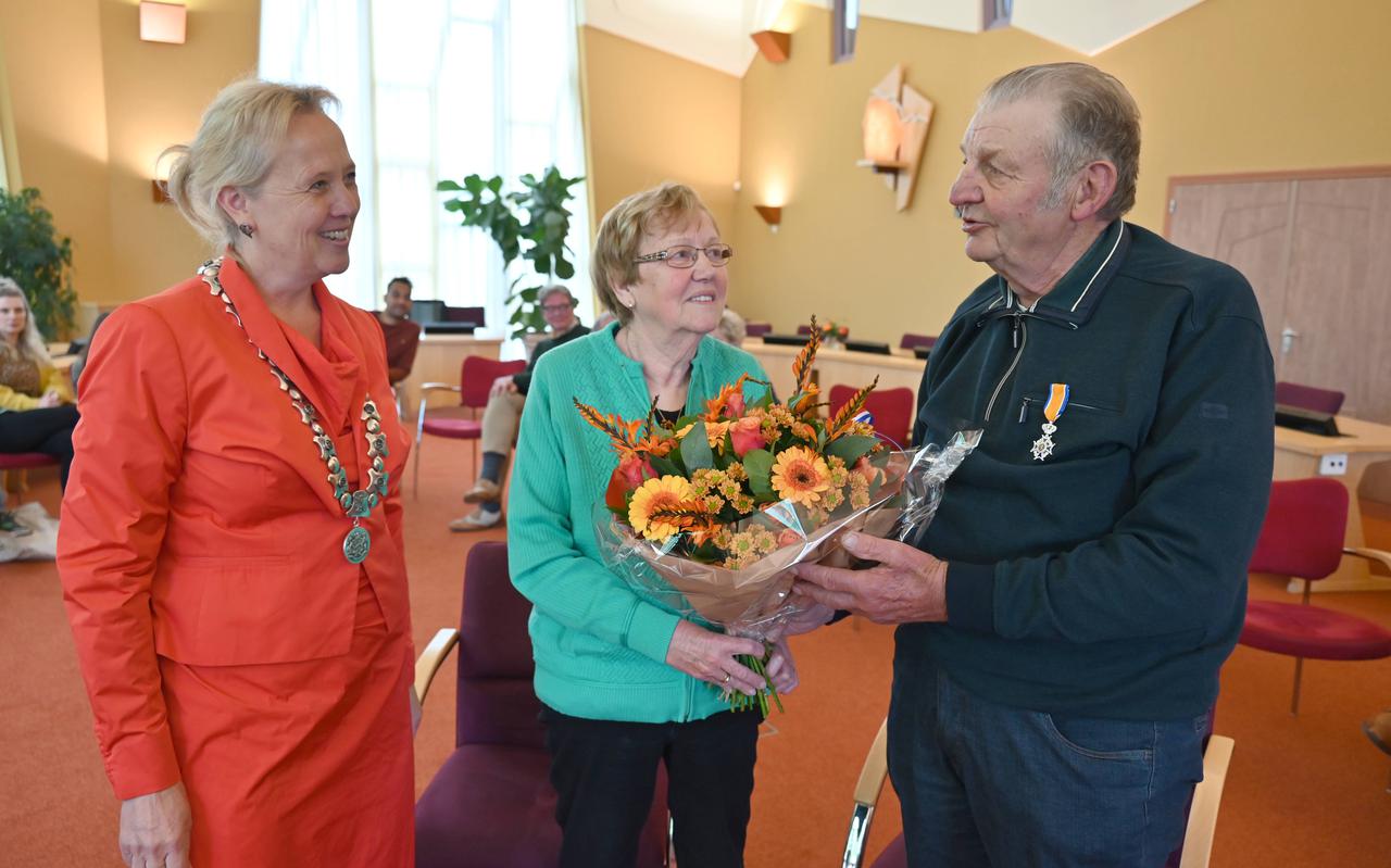 Hendrik Jan Benning met zijn vrouw, nadat het lintje is opgespeld en de bloemen zijn gegeven door burgemeester Inge Nieuwenhuizen.