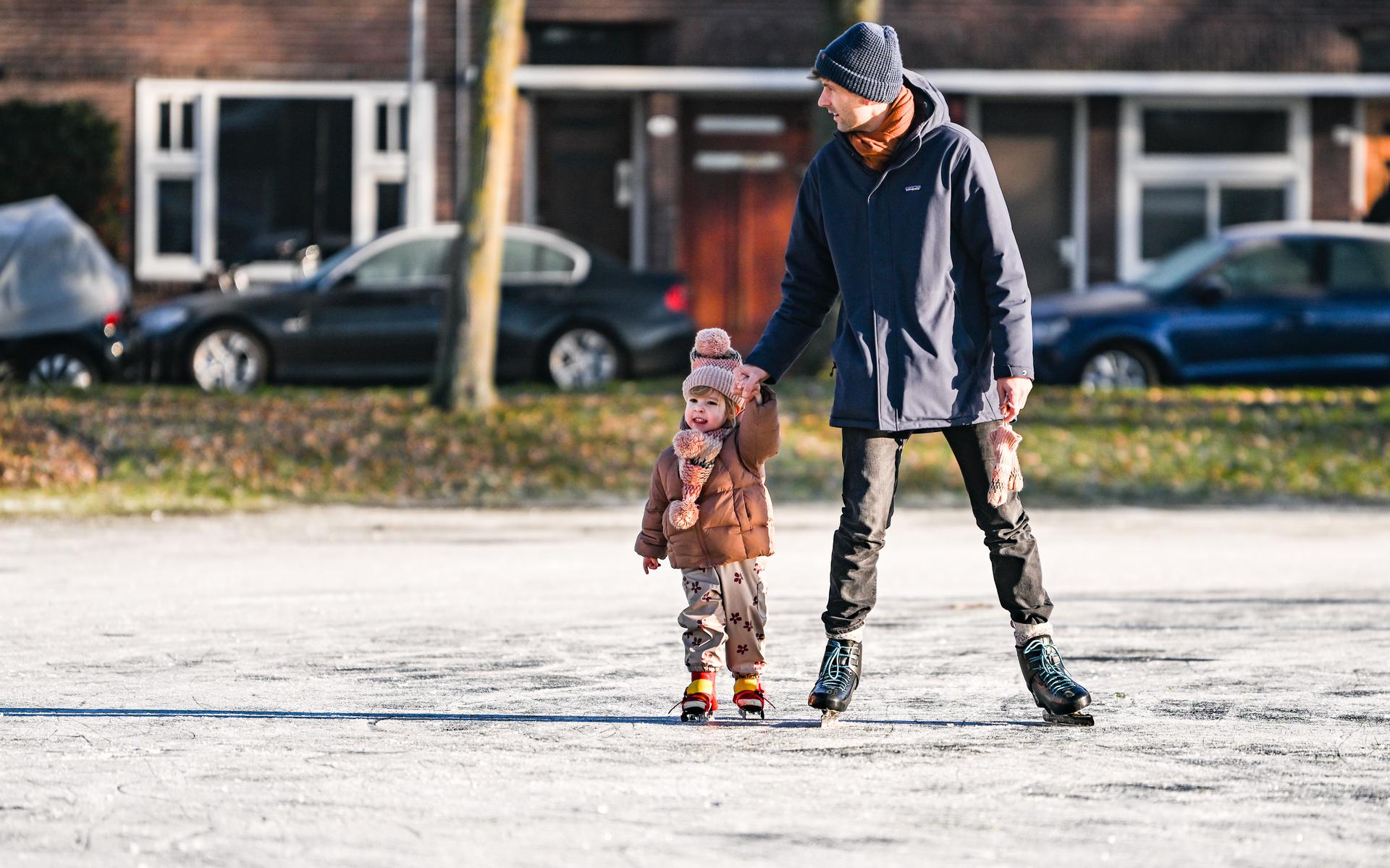 Vader en kind genieten van de ijspret op het Bernoulliplein in Groningen.