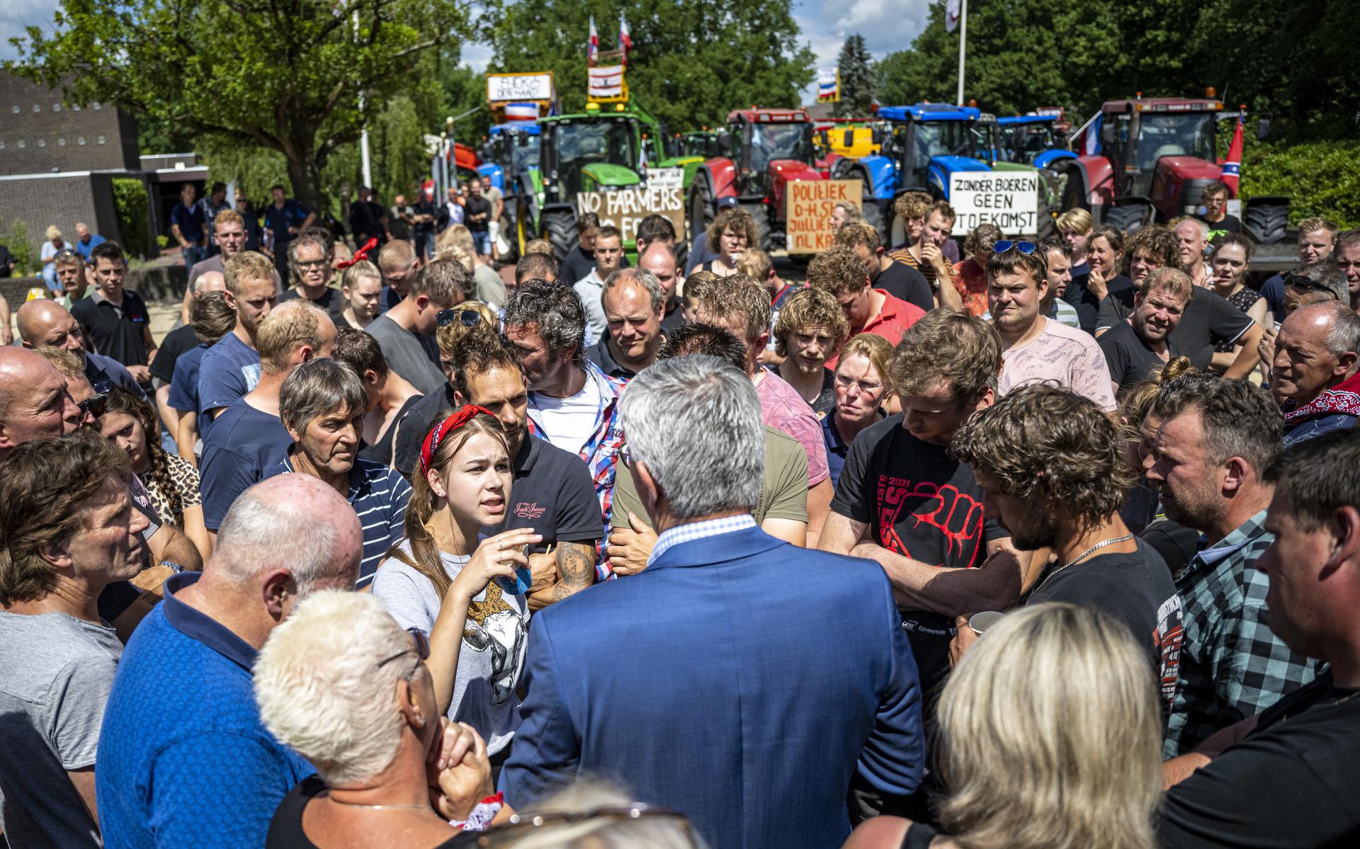 Boeren protesteren in de zomer van 2022 bij het provinciehuis in Assen tegen het stikstofbeleid. Gedeputeerde Henk Jumelet (blauw colbert) staat hen te woord.