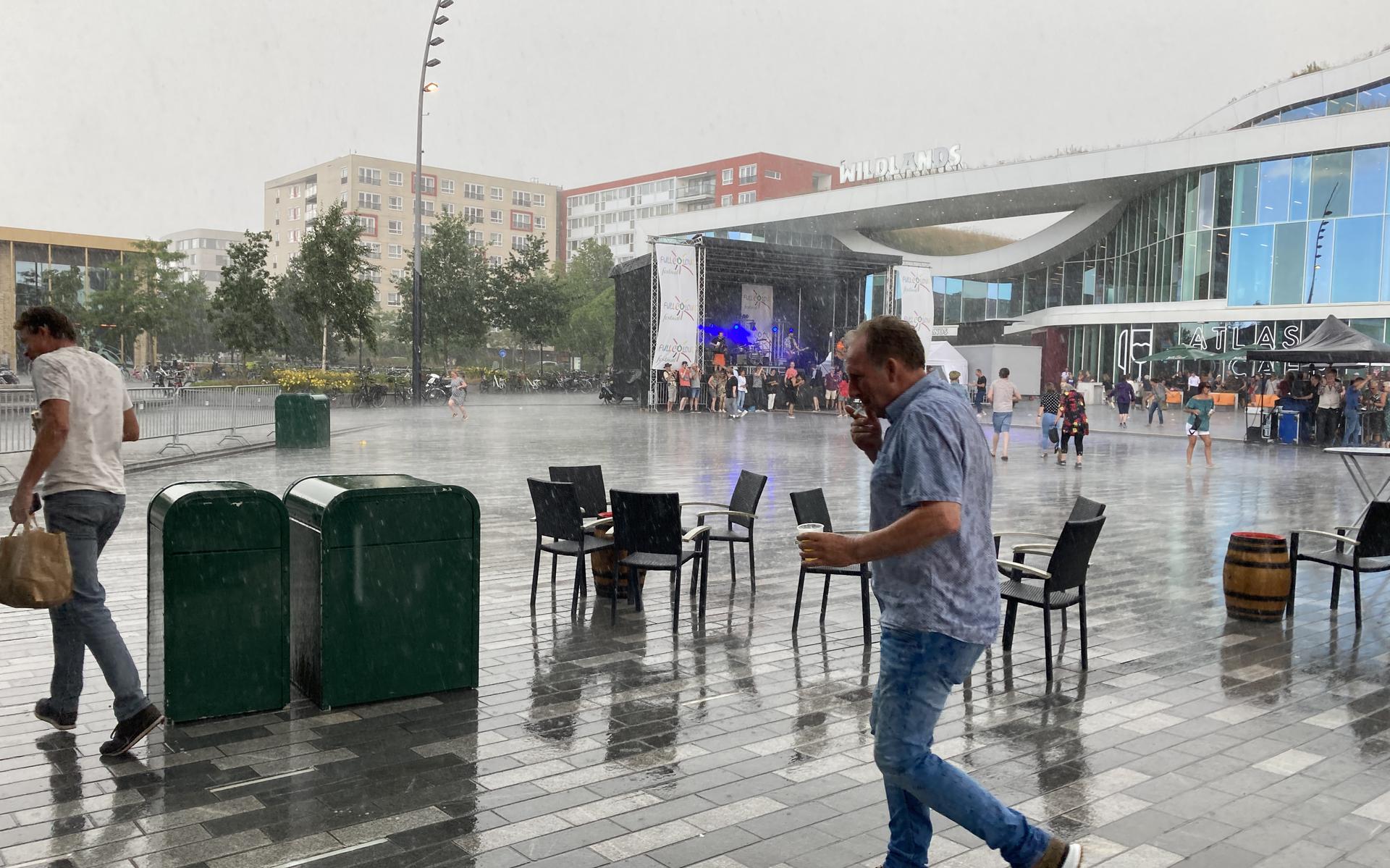 A heavy downpour overwhelms visitors to the Full Color Festival in Emmen.  Driving rain and strong wind lead to some screaming on Raadhuisplein