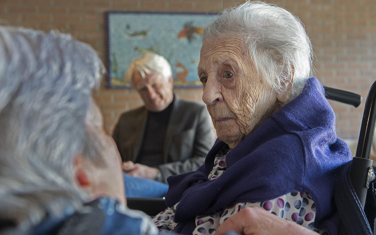 Rie Karmelk op haar 106e verjaardag. Voormalig buurvrouw Geertje Oldejans spreekt haar toe.