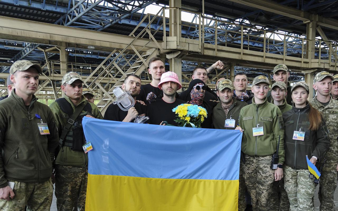 De band Kalush poseert met leden van het leger uit hun land Oekraïne nadat ze de Pools-Oekraïense grens overstaken.
