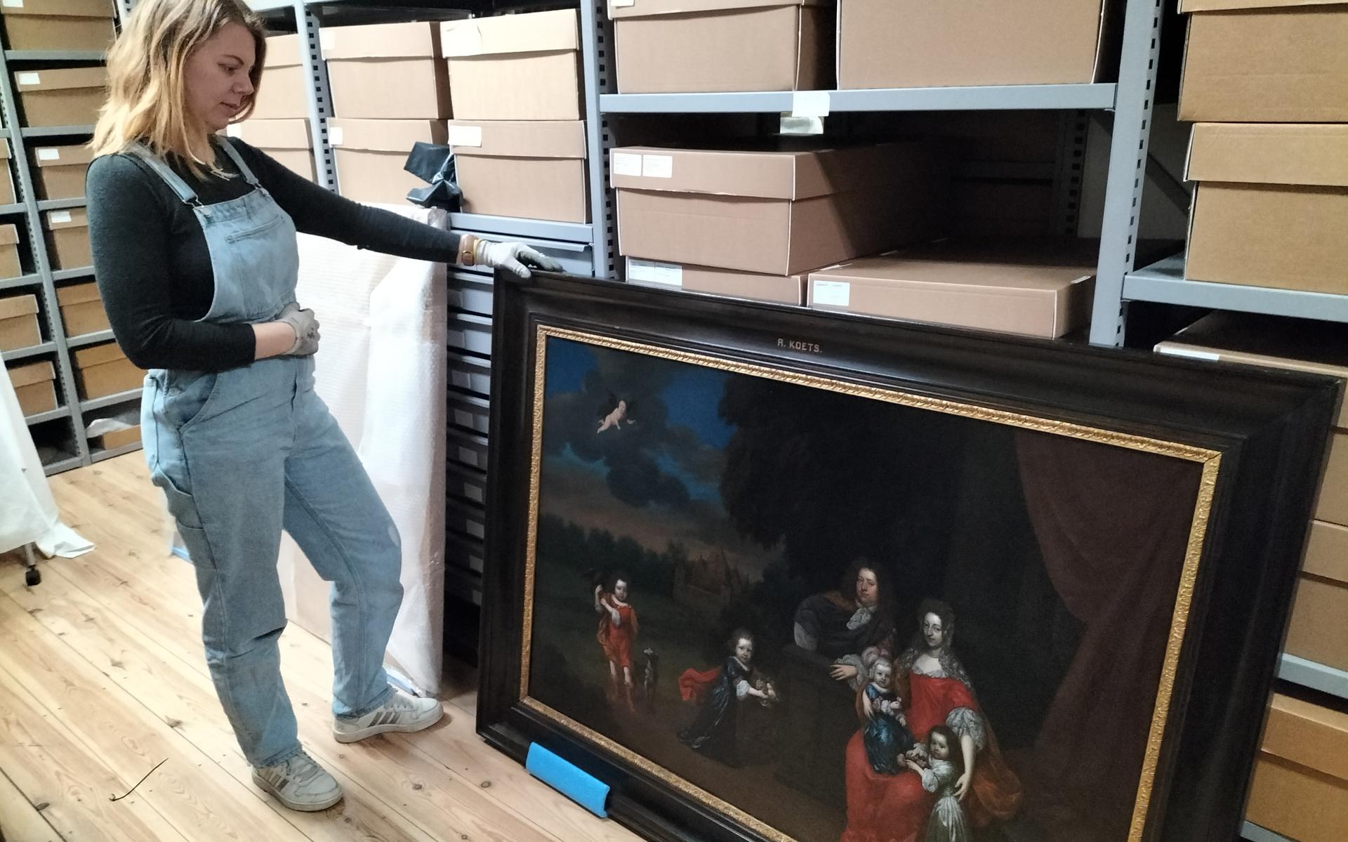 Collectiebeheerder Annemieke Huisman van Openluchtmuseum Het Hoogeland bekijkt het gerestaureerde schilderij.