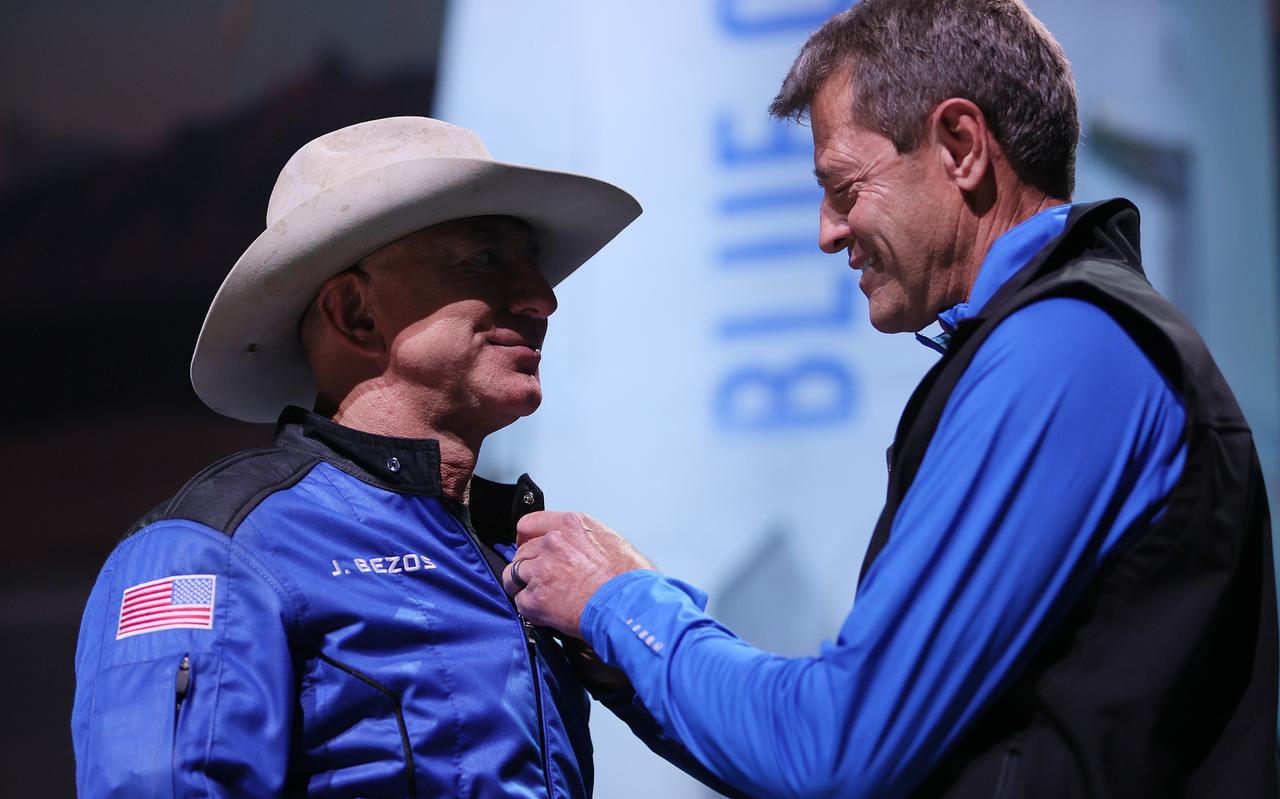 Jeff Bezos (links) ontvangt een soort medaille van oud-ruimtereiziger Jeff Ashby nadat hij in de ruimte heeft gevlogen. Jeff Bezos (links) ontvangt een soort medaille van oud-ruimtereiziger Jeff Ashby nadat hij in de ruimte heeft gevlogen.