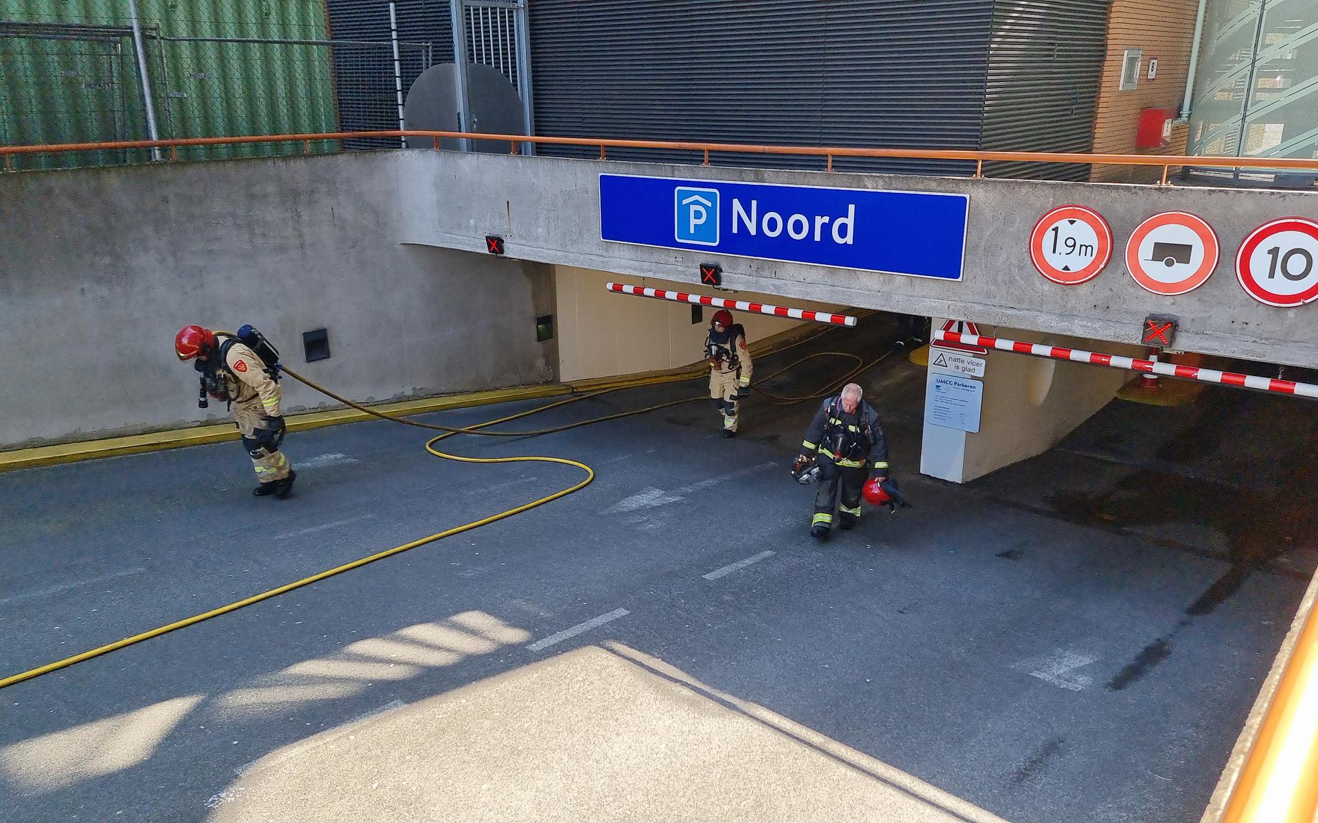 Brandweerlieden blussen vuur in de parkeergarage van het UMCG in Groningen.