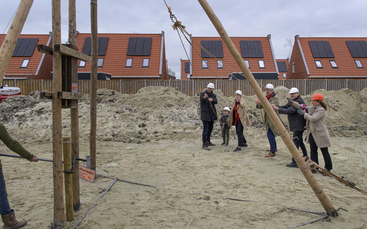 Finn Römeling (5) slaat samen met onder meer directeur Gerke Brouwer van Woongroep Marenland een houten paal in de grond. Het is het startsein voor de bouw van 92 woningen in Appingedam.