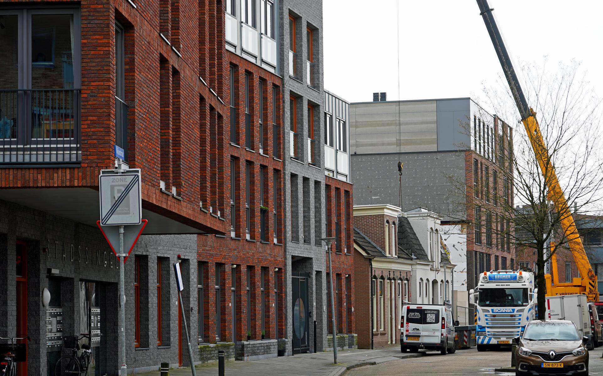 Twee authentieke Asser woningen staan ingeklemd tussen moderne 'reuzen'  in de Nijlandstraat.                               