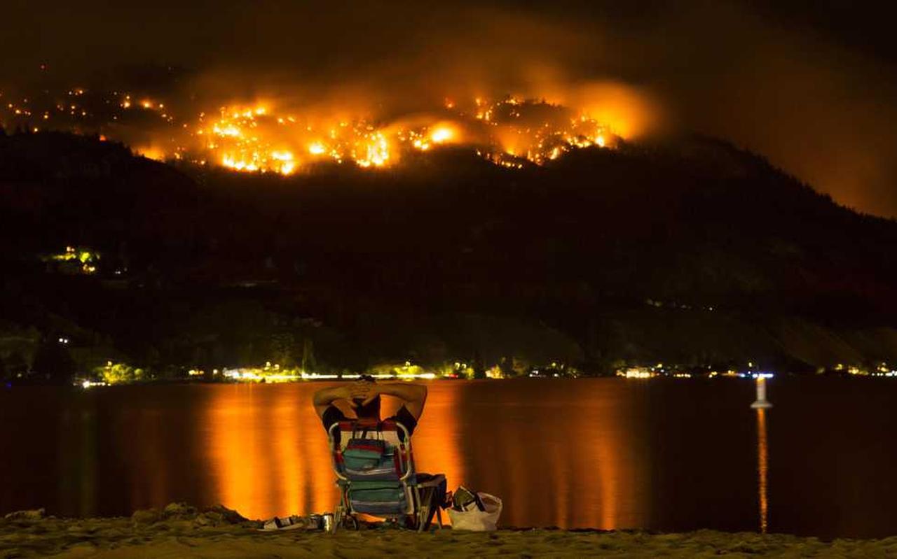 Een man kijkt naar de bosbranden in de westelijke provincie British Columbia in Canada. Een man kijkt naar de bosbranden in de westelijke provincie British Columbia in Canada.