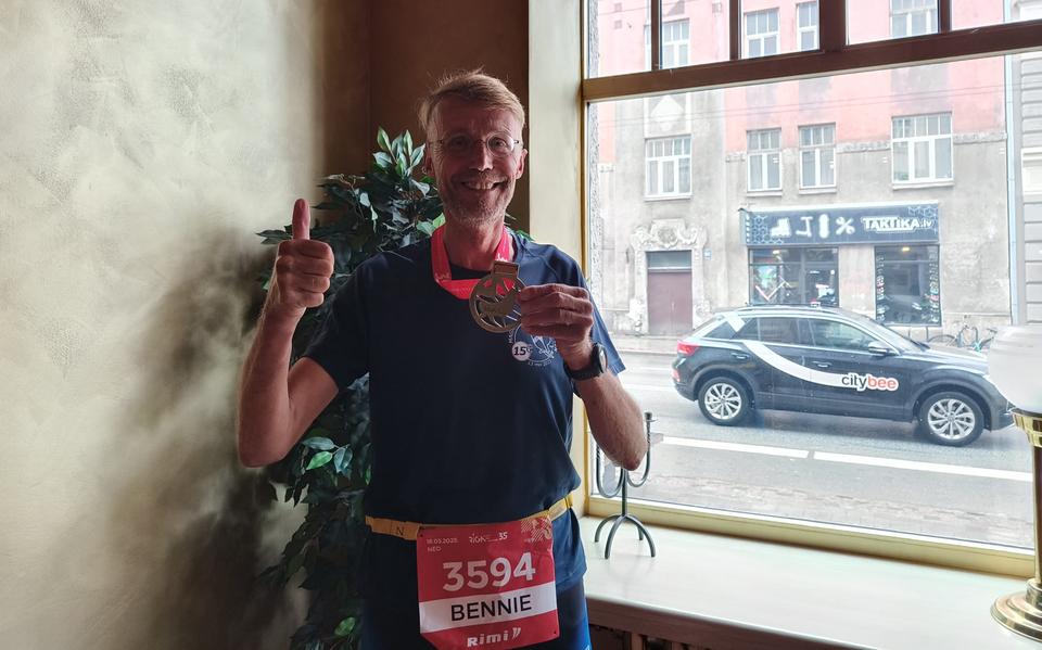 Bennie de Vries uit Stadskanaal toont in het loopshirt van de Run van Gieten de medaille na zijn 1000ste (ultra)marathon in Riga.