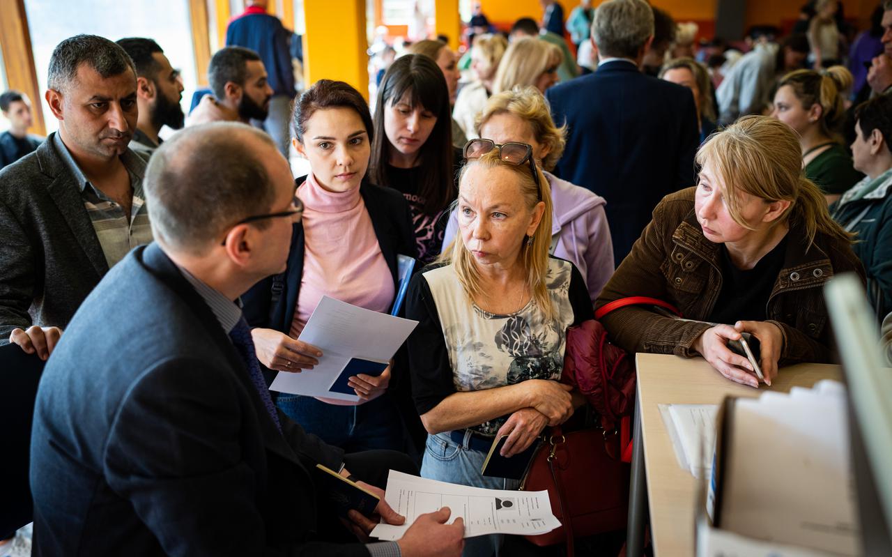 Ambassadepersoneel helpt gevluchte Oekraïners aan documenten in het Maartenscollege in Haren.