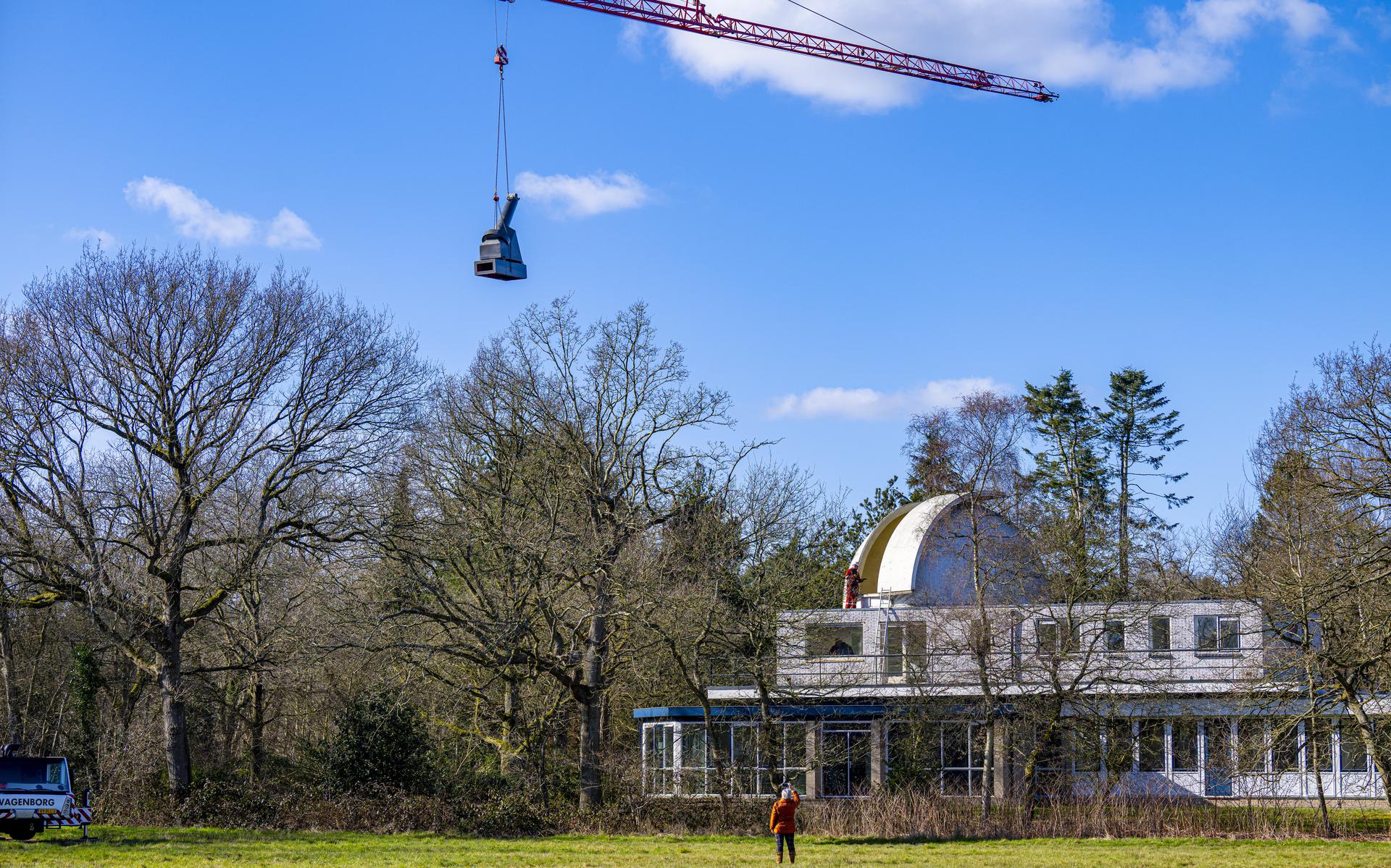 De telescoop wordt met een grote kraan teruggezet in de voormalige J.C. Kapteyn Sterrenwacht in Roden.