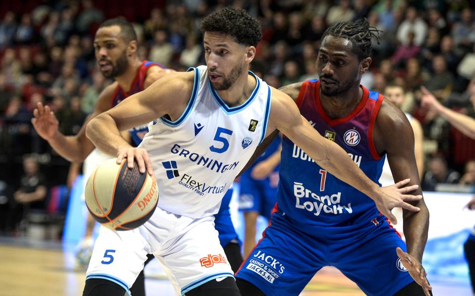 Donar-aanvoerder Leon Williams probeert zijn voormalige ploeggenoot Donte Thomas van zich af te houden.