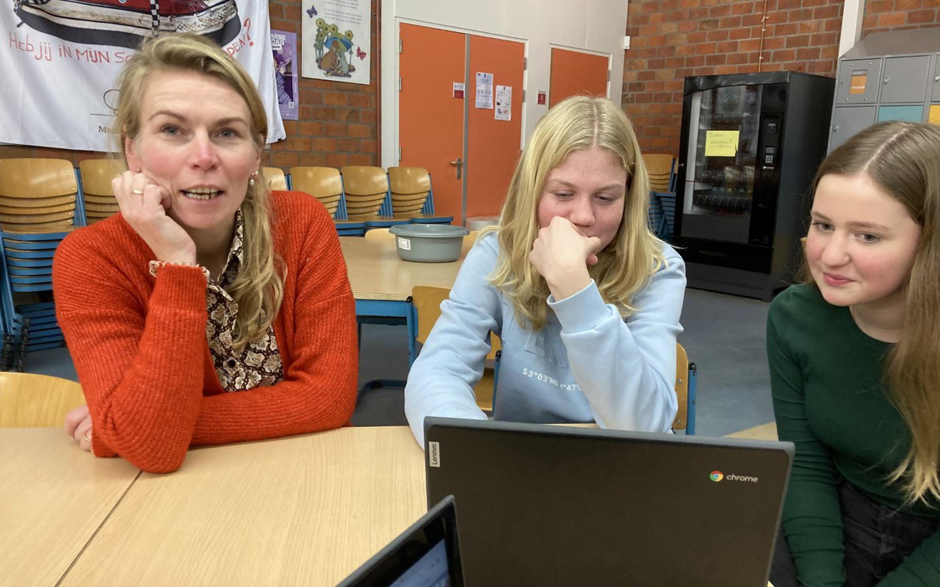 Locatiedirecteur Judith Veldhuis van het Lauwers College in Grijpskerk in gesprek met twee leerlingen. 